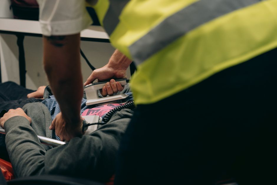 Paramedics provide urgent care to a patient on a stretcher during an emergency situation. - Adding income