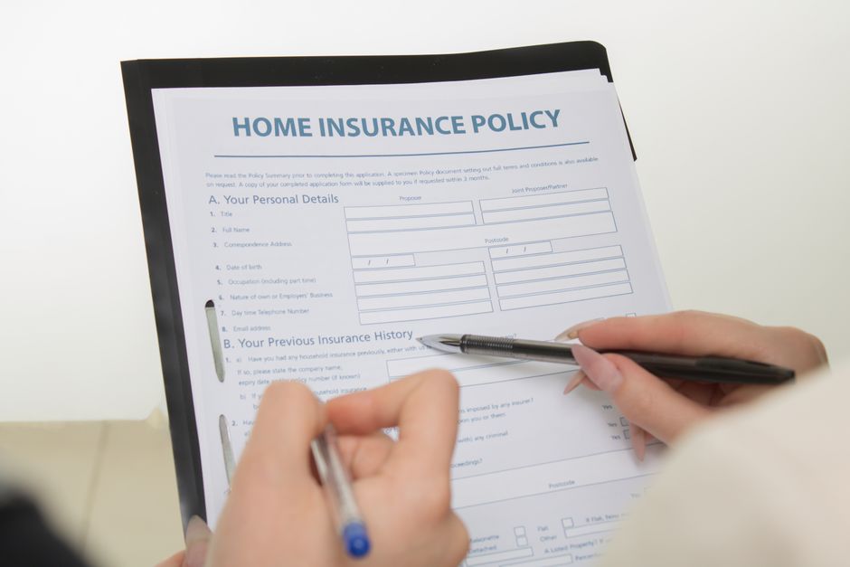 Hands holding pens filling out a home insurance policy document for coverage details. - What if I’m offered a state employee health benefit plan?