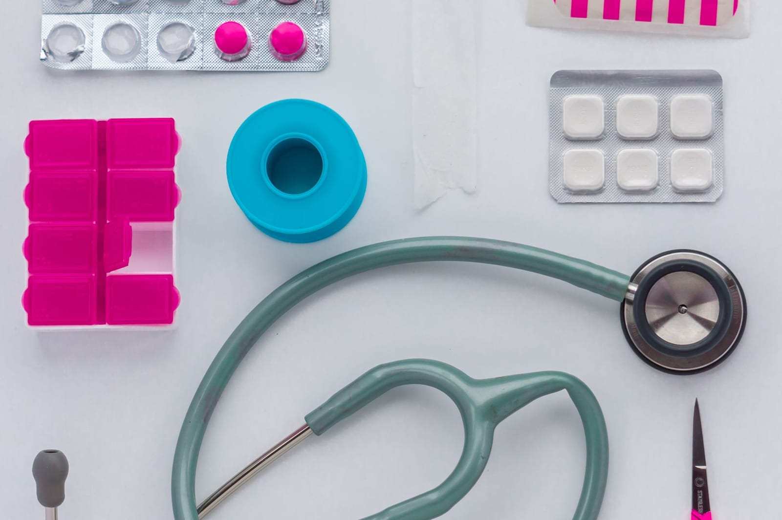 Top view of medical tools, pills, and equipment arranged on a white background, conveying healthcare essentials. - What do I need to apply for coverage?