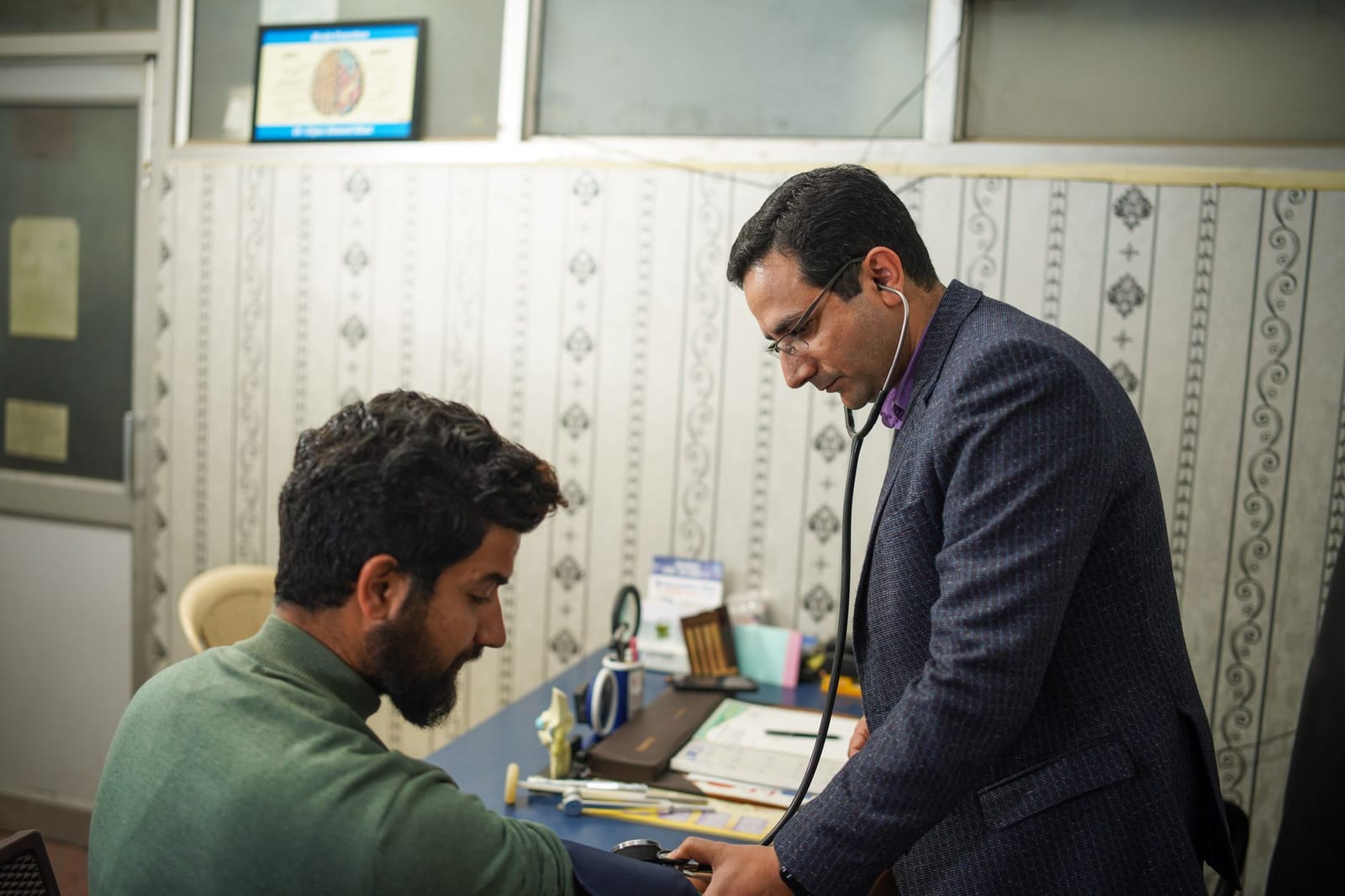 A doctor uses a stethoscope for a patient's health check-up in a clinic. - Tips about the Health Insurance Marketplace®