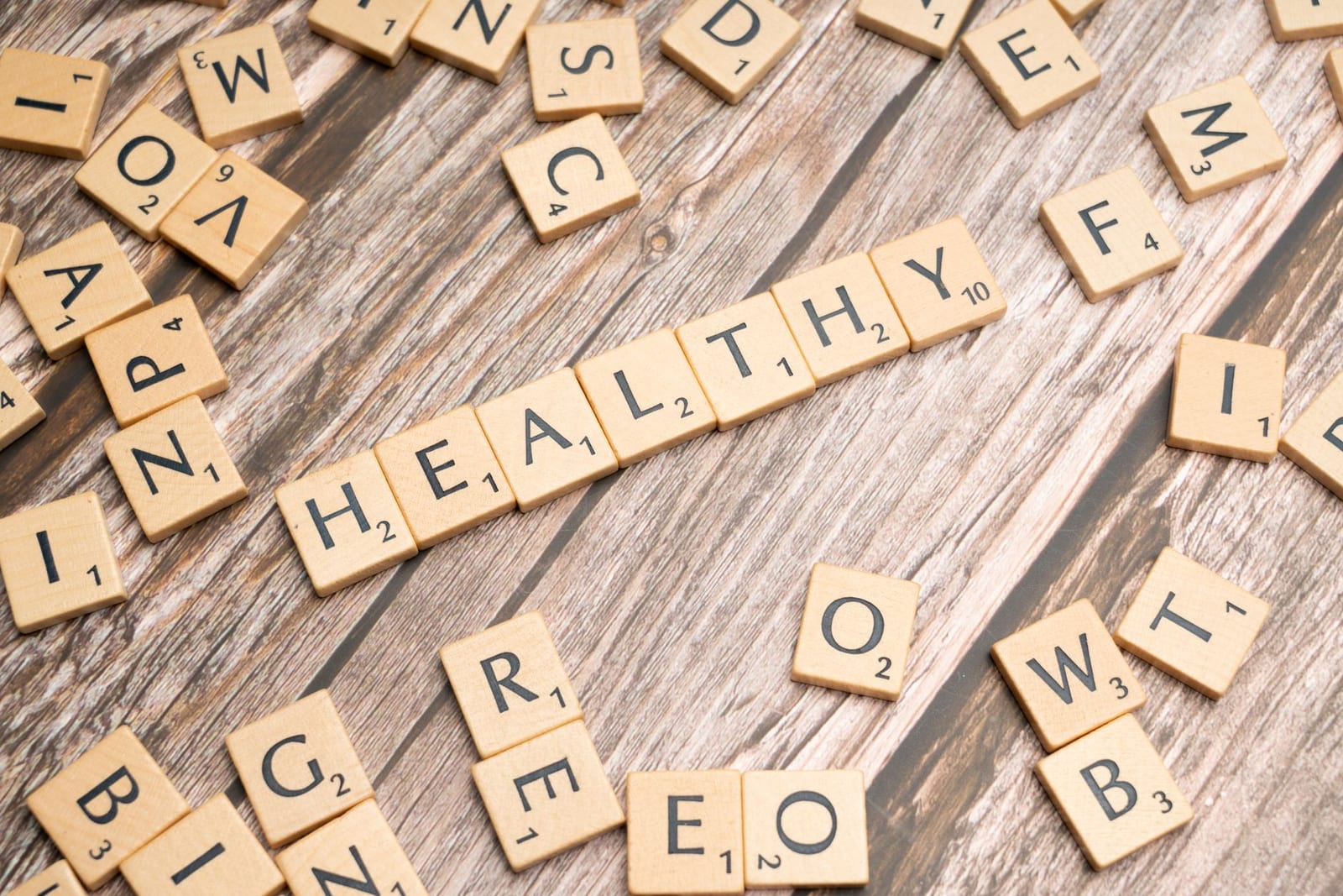 Wooden letter tiles arranged on a wooden surface spelling out 'healthy', symbolizing wellness. - Health coverage exemptions for the 2016 tax year only