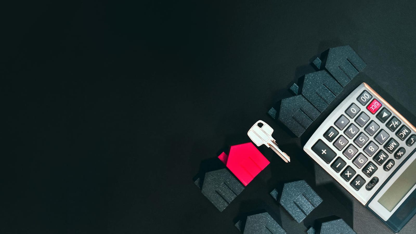 Real estate concept image featuring a calculator, houses, and a key on a black background. - Get or change coverage outside of Open Enrollment