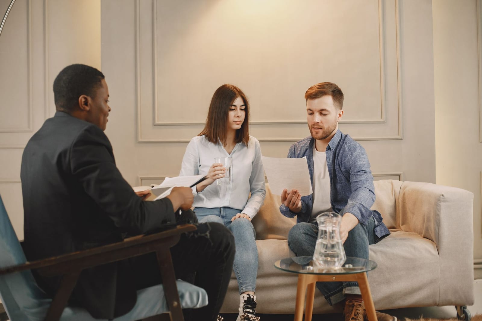 Therapist counseling couple with documents in contemporary office setting. - Find & use Form 1095-A