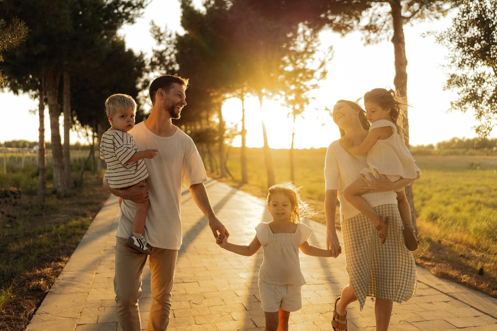 A joyful family walking together on a sunlit path during sunset, enjoying an outdoor stroll. - You're leaving HealthCare.gov to complete a Marketplace appeal form
