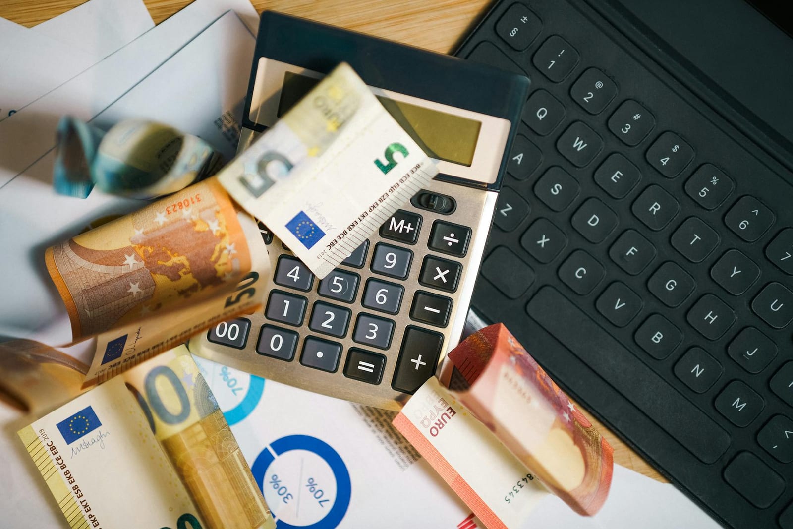 A financial setup featuring euro banknotes, a calculator, and a laptop keyboard for business analysis. - More information about health care for people with disabilities