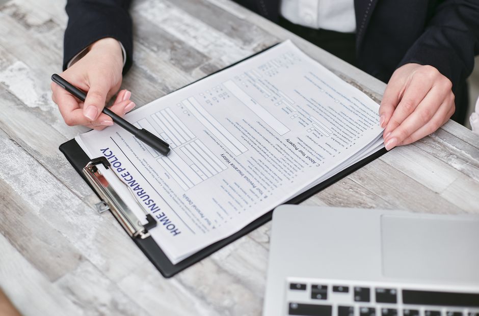 Close-up of hands reviewing a home insurance policy, emphasizing professionalism and finance. health insurance