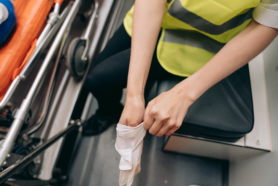 A paramedic removing gloves inside an ambulance, showcasing emergency medical services. health insurance