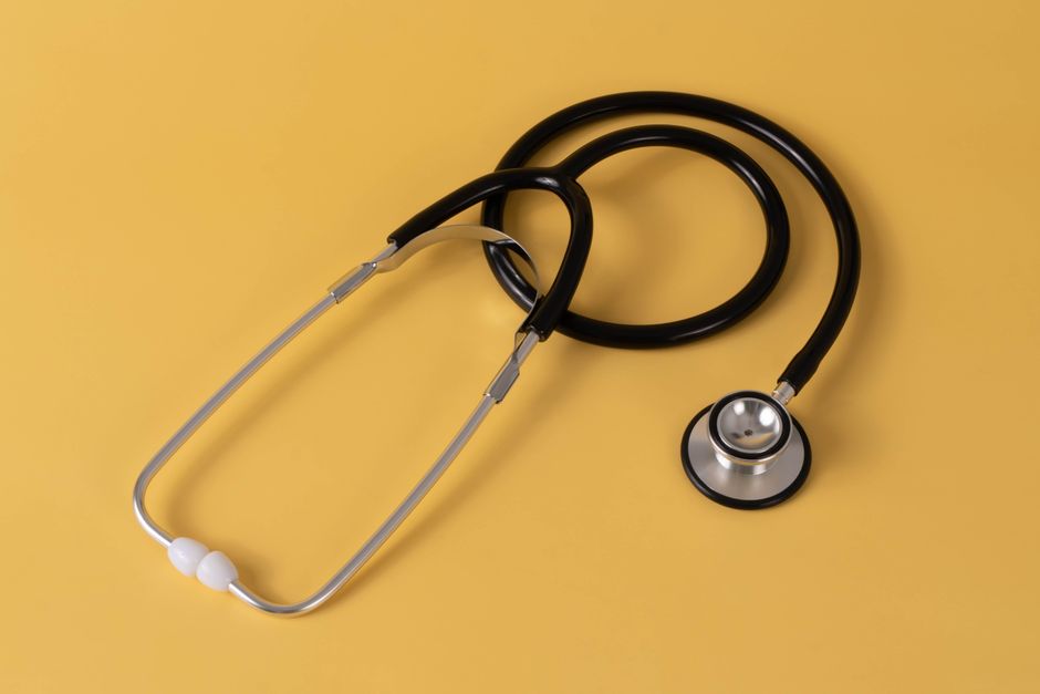 Close-up of a stethoscope on a yellow background, symbolizing healthcare. health insurance