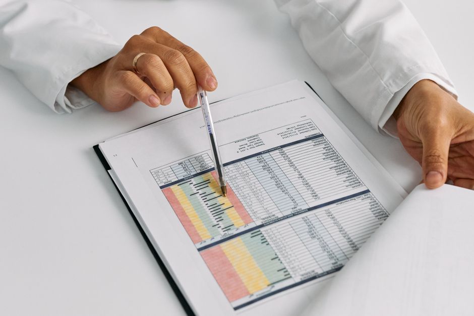 Doctor hands examining and pointing at medical charts in a close-up view. health insurance