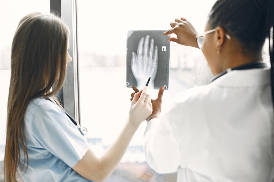 Two doctors examine a hand X-ray in a hospital setting. health insurance