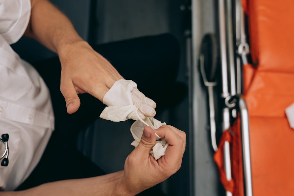 Close-up of a medical worker removing gloves in an ambulance setting, emphasizing hygiene and care. health insurance