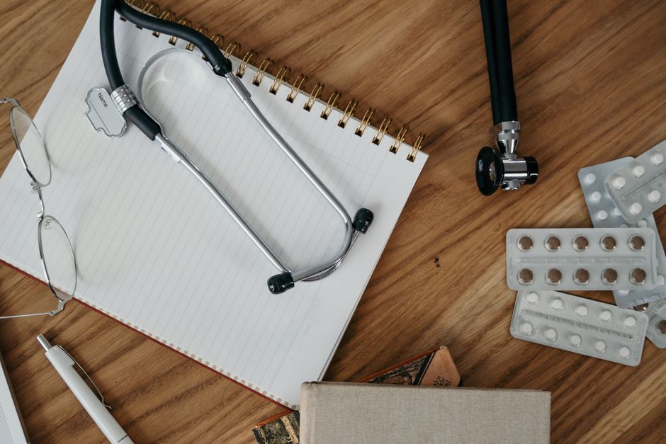Flat lay of medical tools and supplies on a wooden desk surface. health insurance