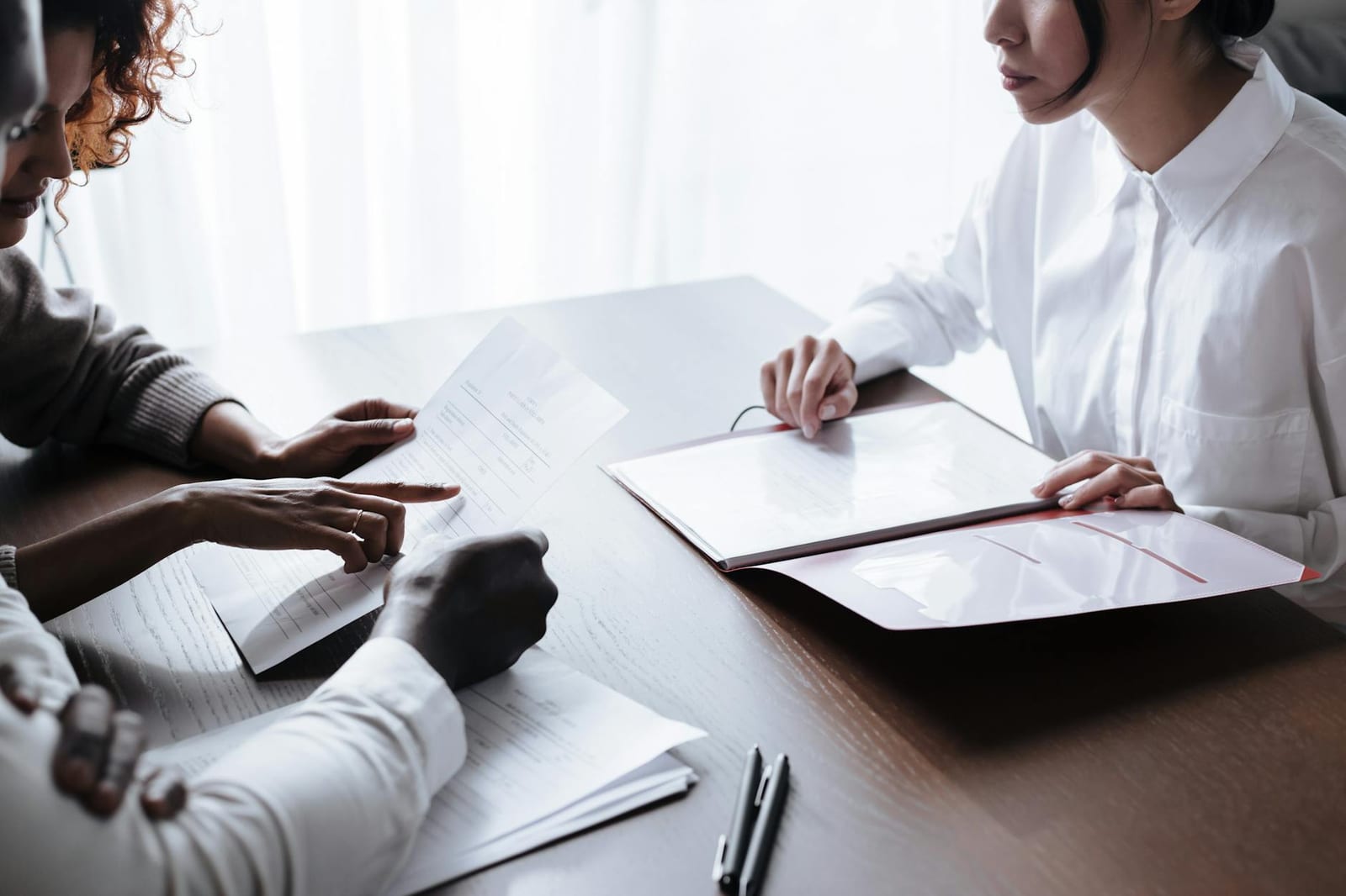 A diverse group of adults reviewing documents during a meeting at an office table. health insurance