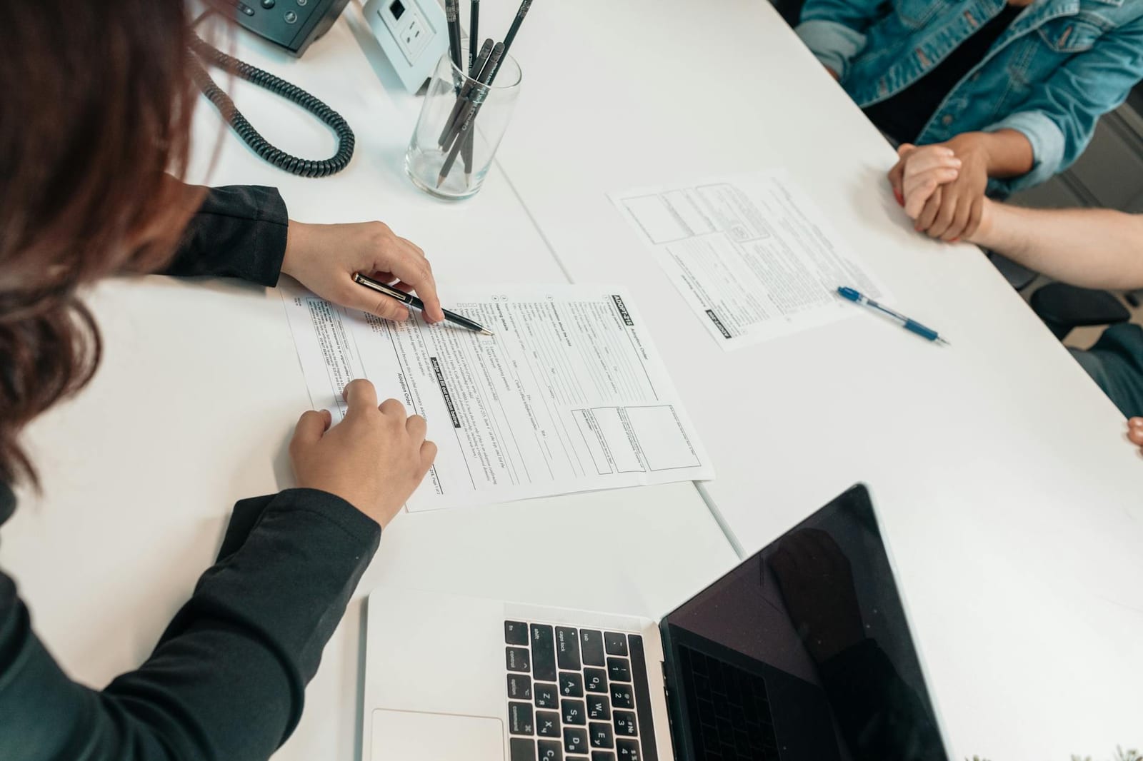 A professional meeting with document signing at an office desk, focusing on teamwork. health insurance
