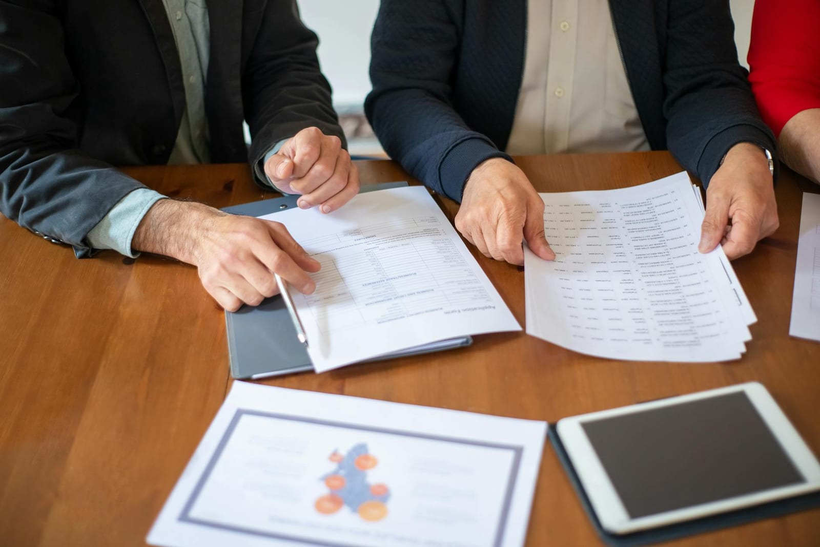 Two business professionals discussing and reviewing documents during a meeting. health insurance