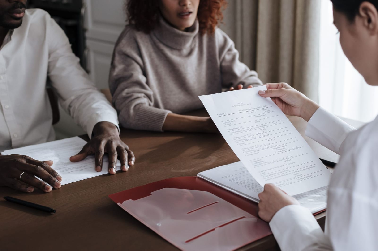 A diverse group of individuals discussing documents in a professional office environment. health insurance